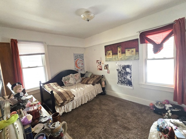 bedroom with multiple windows and dark colored carpet