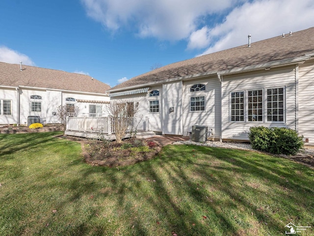 rear view of property featuring a lawn, cooling unit, and a wooden deck