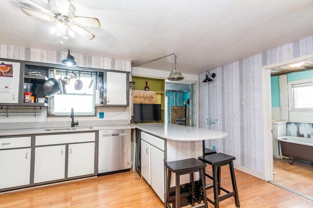53075 M 51 N, Dowagiac, MI 49047 - kitchen featuring stainless steel dishwasher, a sink, wallpapered walls, light wood finished floors, and light countertops