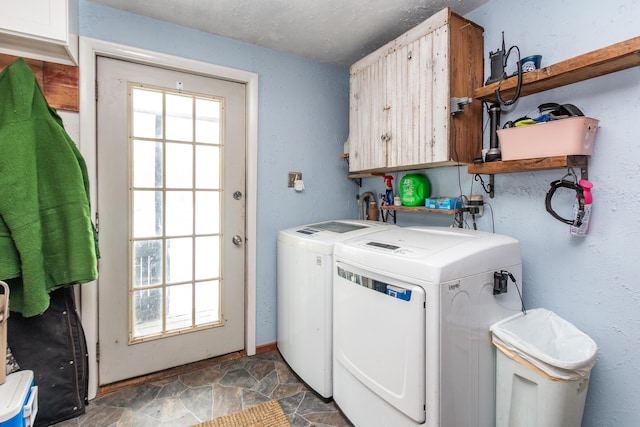 clothes washing area with cabinets and washing machine and dryer