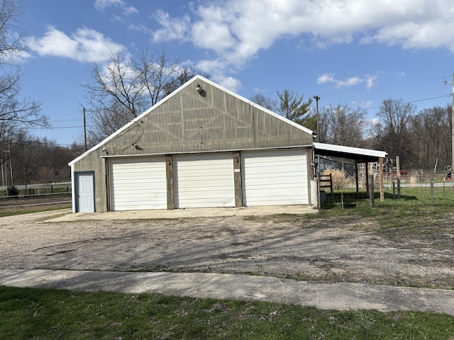 garage with a detached garage and fence