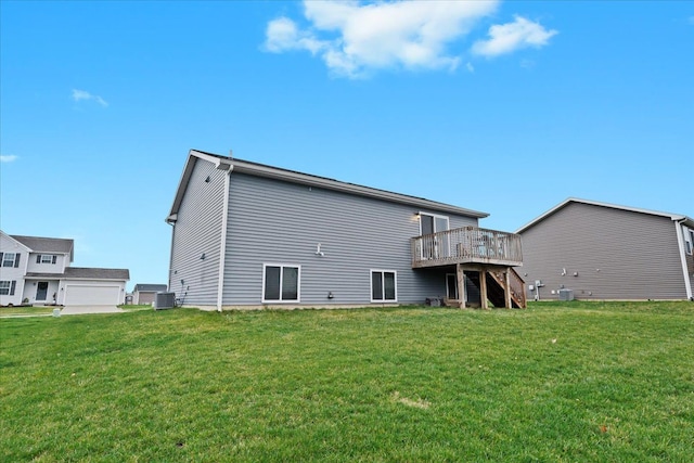 rear view of property featuring a lawn, central AC unit, and a deck