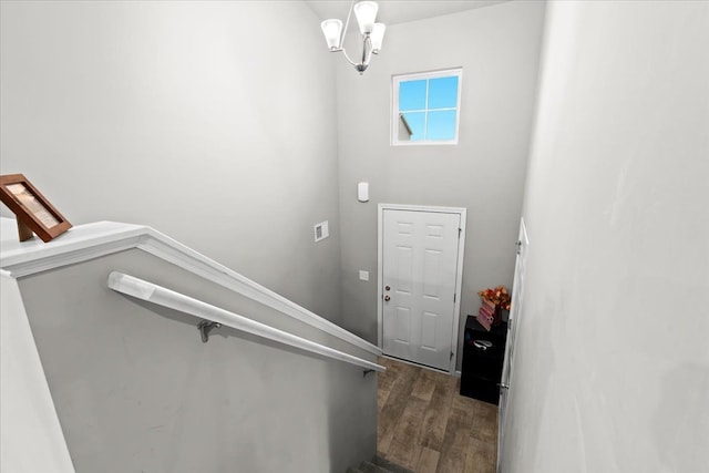 stairs featuring hardwood / wood-style floors and a notable chandelier