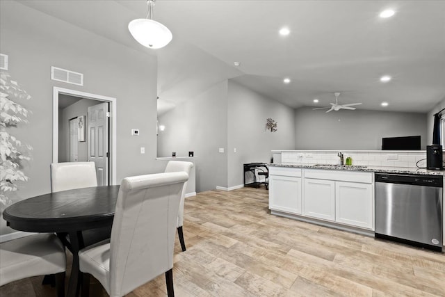 dining area featuring ceiling fan, light wood-type flooring, lofted ceiling, and sink