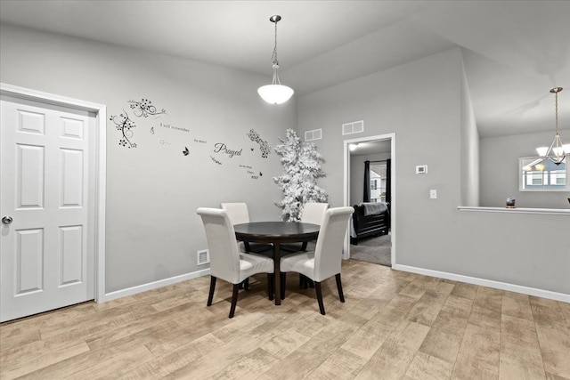 dining room with light hardwood / wood-style floors and a notable chandelier