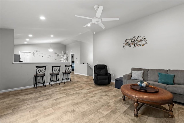 living room featuring ceiling fan, vaulted ceiling, and light wood-type flooring