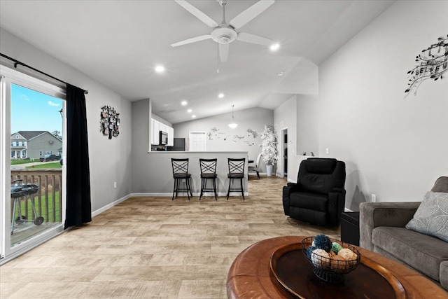 living room with light hardwood / wood-style floors, ceiling fan, and lofted ceiling