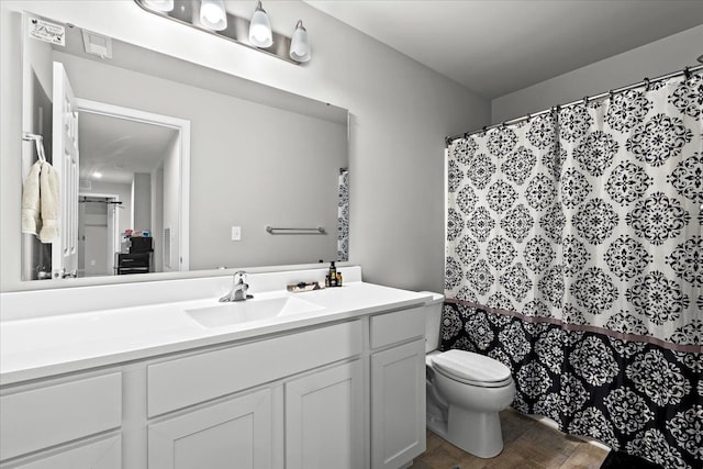 bathroom with hardwood / wood-style flooring, vanity, toilet, and a shower with shower curtain