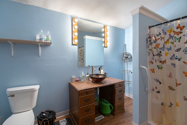 bathroom featuring curtained shower, a textured ceiling, toilet, vanity, and hardwood / wood-style flooring