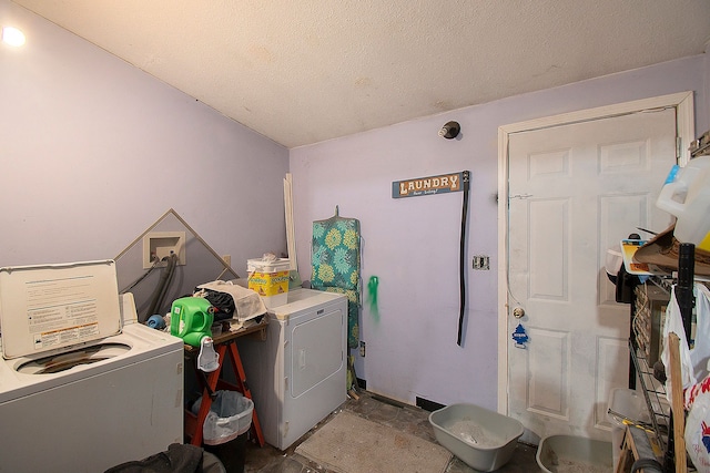 laundry area with washer and clothes dryer and a textured ceiling