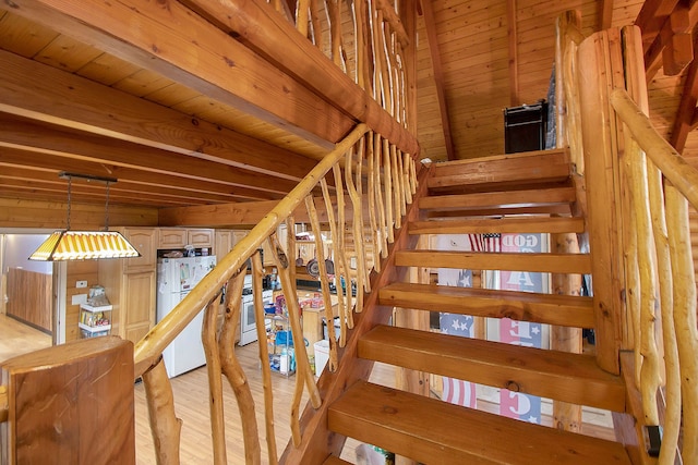 stairs featuring beamed ceiling, hardwood / wood-style flooring, and wood ceiling