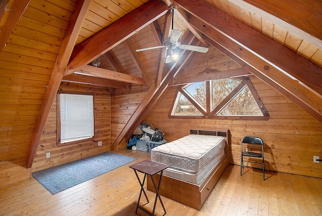 bedroom with lofted ceiling with beams, light hardwood / wood-style flooring, and wooden walls