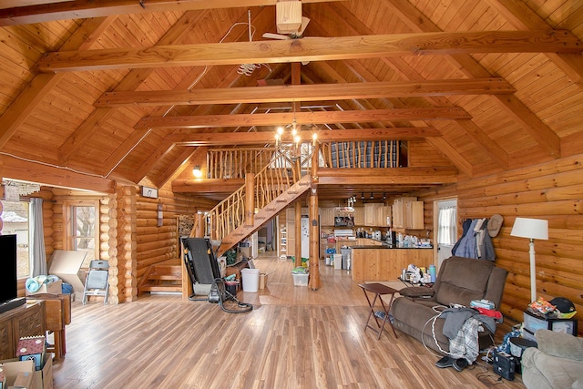 living room featuring beam ceiling, rustic walls, a healthy amount of sunlight, and wood-type flooring