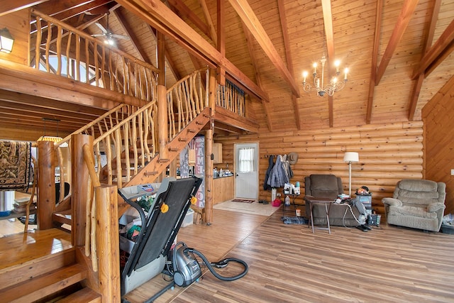 workout room with ceiling fan with notable chandelier, hardwood / wood-style flooring, high vaulted ceiling, and wood ceiling