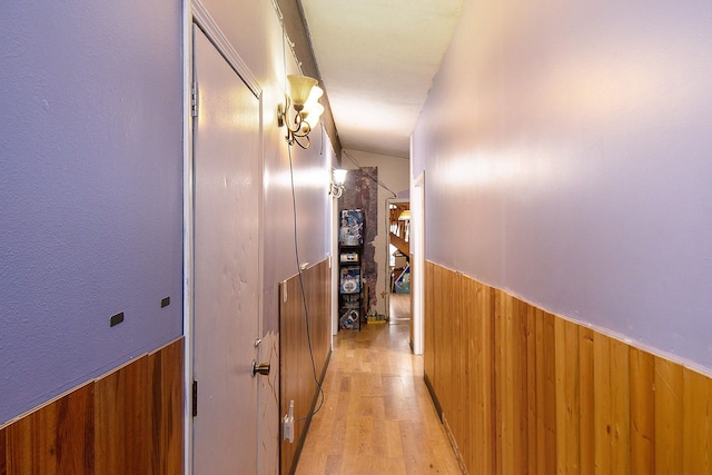 hall featuring wood walls and light hardwood / wood-style floors