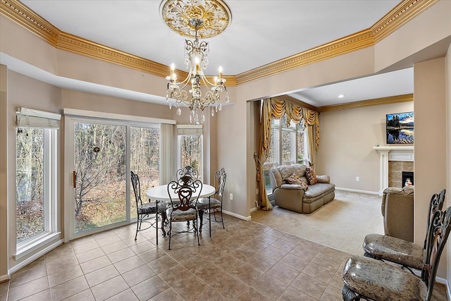 dining space with a notable chandelier, light tile patterned floors, a tile fireplace, and a wealth of natural light