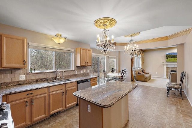 kitchen featuring sink, hanging light fixtures, backsplash, a tiled fireplace, and a kitchen island