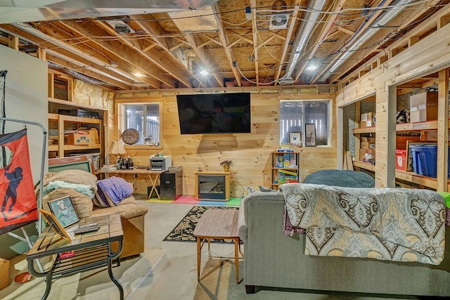 living room featuring wood walls and concrete flooring