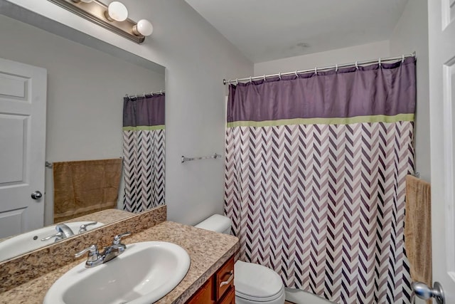 bathroom featuring vanity, a shower with shower curtain, and toilet