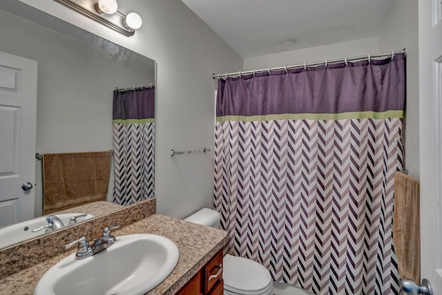 bathroom featuring vanity, toilet, and walk in shower