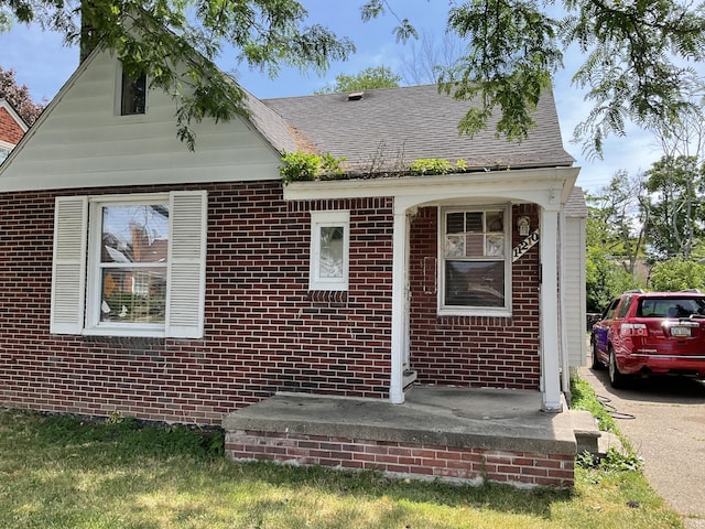 view of front of house with brick siding and a shingled roof