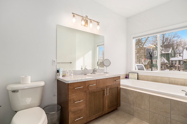 bathroom with tile patterned floors, tiled bath, vanity, and toilet