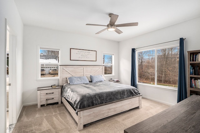 bedroom with multiple windows, light carpet, and ceiling fan