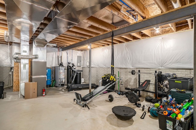 workout area featuring electric panel, gas water heater, brick wall, and heating unit