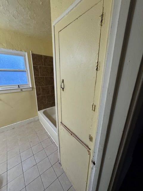 bathroom with tile patterned floors and a bathing tub