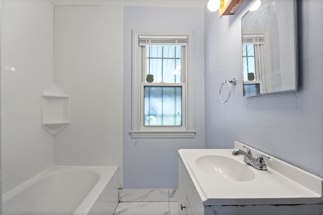 bathroom with a tub and vanity