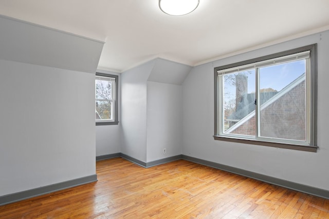 bonus room featuring light hardwood / wood-style flooring, plenty of natural light, and lofted ceiling