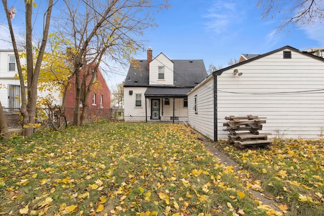 rear view of property featuring a lawn