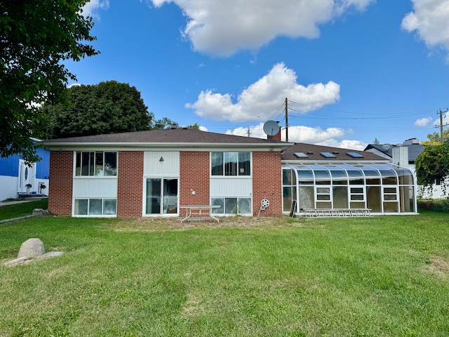 back of house with a yard and a sunroom