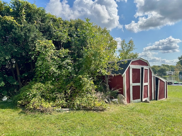 view of outbuilding with a yard and a water view