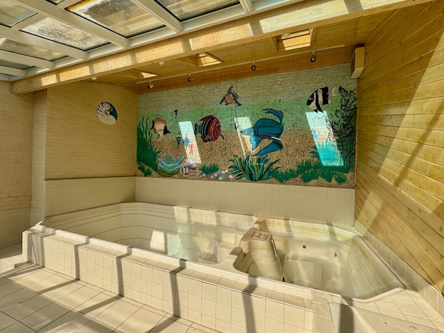 bathroom with tile patterned floors and tiled tub