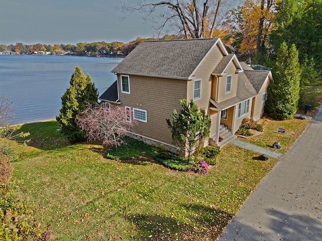 view of side of property with a lawn and a water view