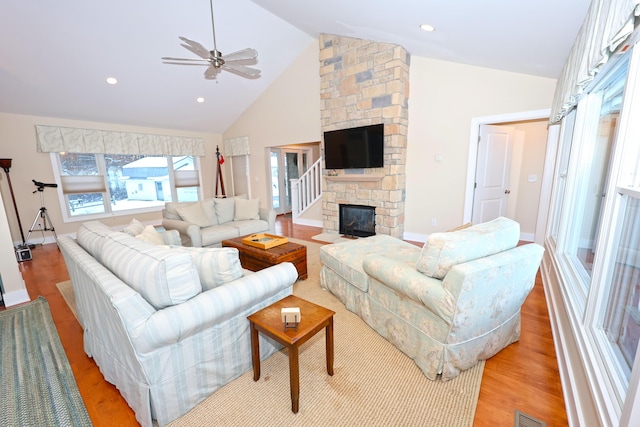 living room with a fireplace, high vaulted ceiling, light hardwood / wood-style flooring, and ceiling fan