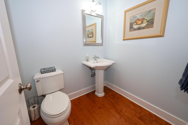 bathroom with toilet and hardwood / wood-style flooring