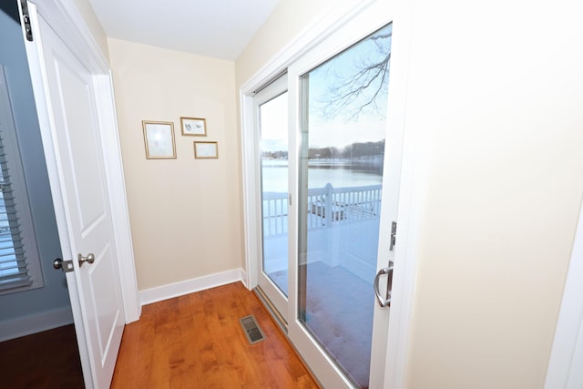 doorway to outside with a water view and wood-type flooring