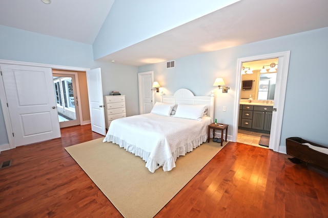 bedroom featuring lofted ceiling, ensuite bathroom, and dark hardwood / wood-style floors