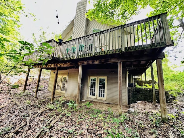 view of side of home with a wooden deck and french doors