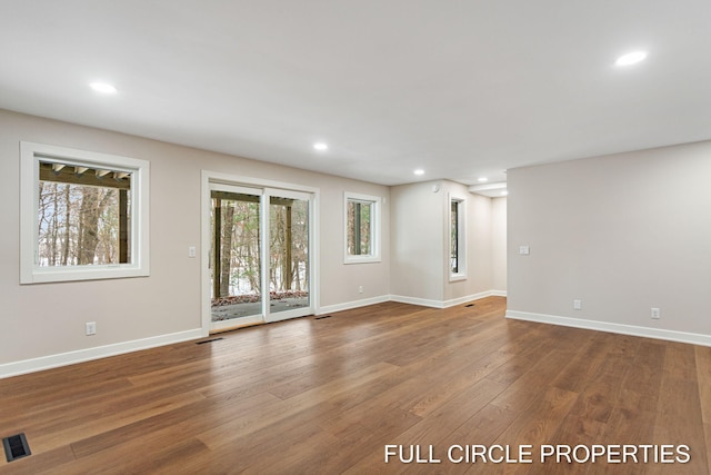 empty room with hardwood / wood-style floors and a wealth of natural light