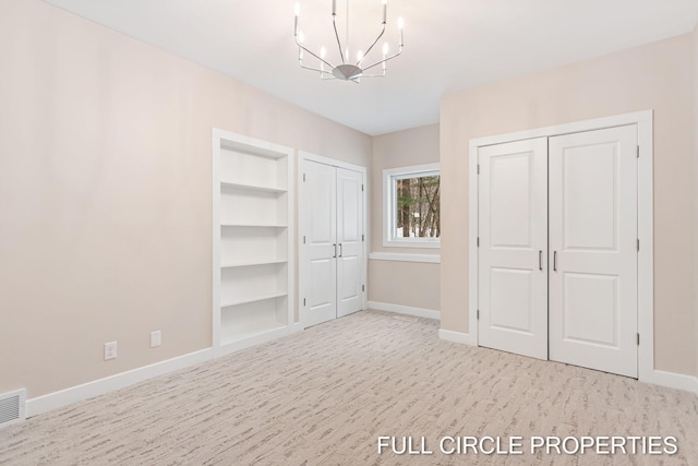 unfurnished bedroom featuring light colored carpet and an inviting chandelier