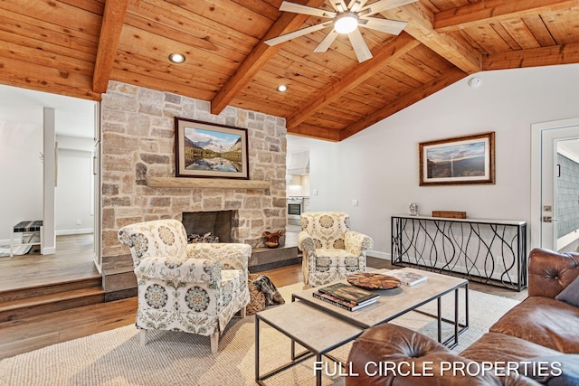 living room with lofted ceiling with beams, light hardwood / wood-style flooring, ceiling fan, a fireplace, and wood ceiling