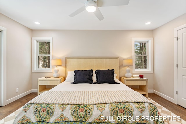 bedroom featuring multiple windows, wood-type flooring, and ceiling fan