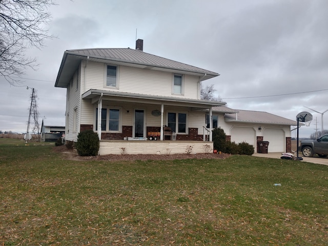 view of front of property featuring covered porch, a front yard, and a garage