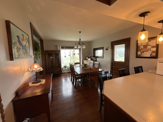 dining space featuring an inviting chandelier and dark hardwood / wood-style flooring