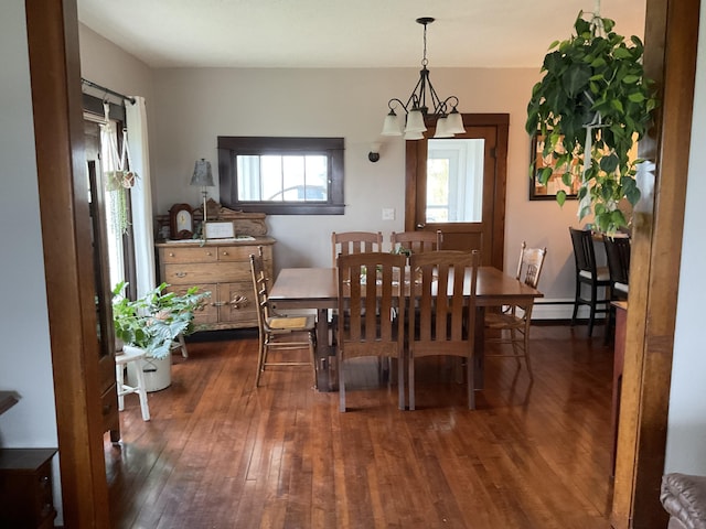 dining area with a baseboard heating unit, a notable chandelier, and dark hardwood / wood-style flooring