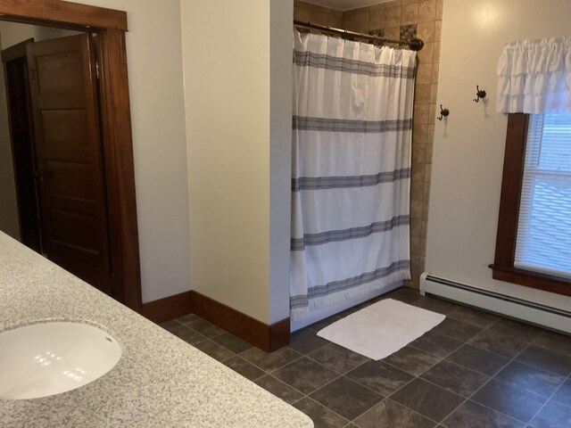 bathroom featuring a baseboard heating unit, walk in shower, and vanity