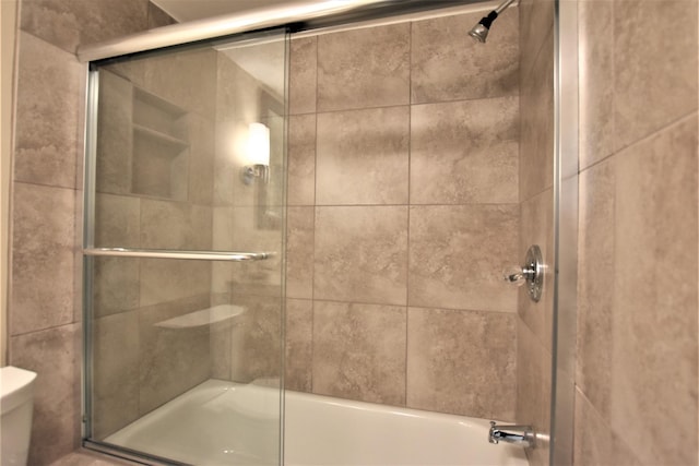 bathroom featuring enclosed tub / shower combo and toilet